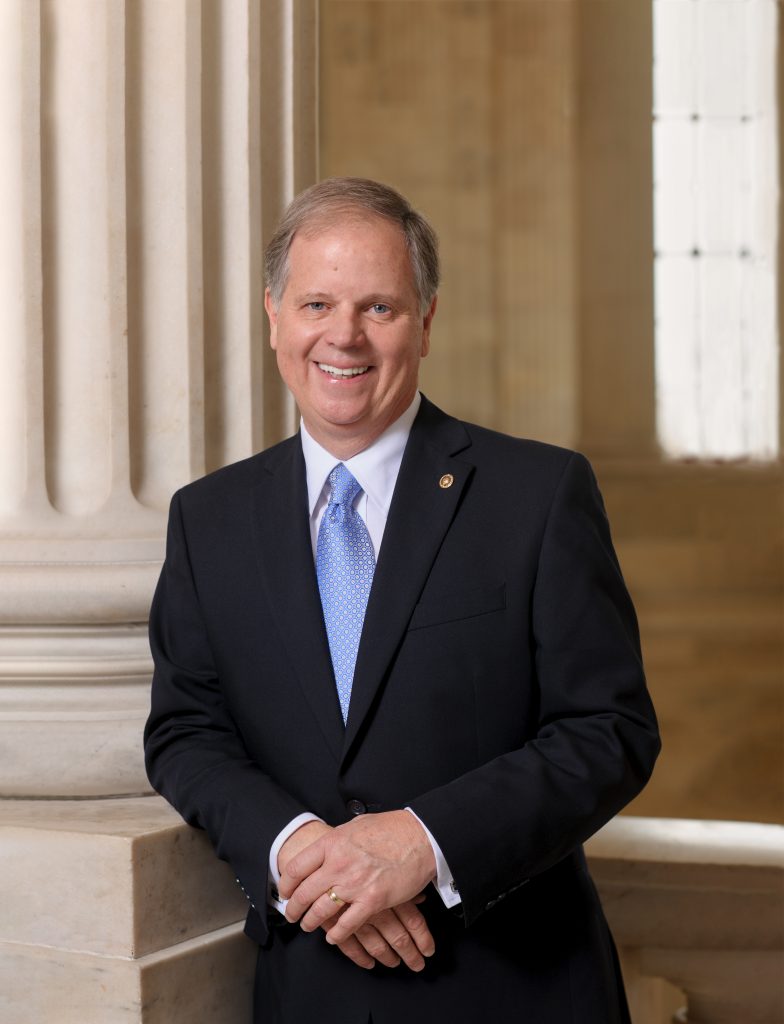 Doug Jones standing by a column